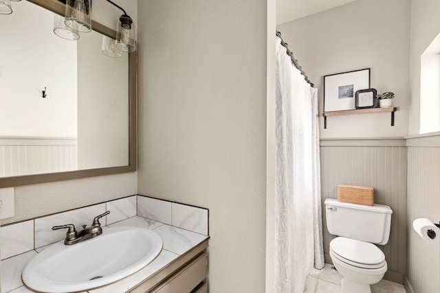 223 12th St N, Great Falls, MT 59401 - full bath with a wainscoted wall, vanity, curtained shower, and tile patterned floors