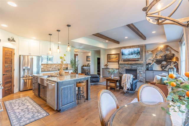 128 Antler Peak Ln, Kalispell, MT 59901 - kitchen featuring stainless steel appliances, white cabinets, light wood-style flooring, open floor plan, and recessed lighting