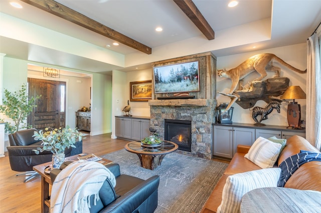 128 Antler Peak Ln, Kalispell, MT 59901 - living area featuring beamed ceiling, a stone fireplace, wood finished floors, and recessed lighting