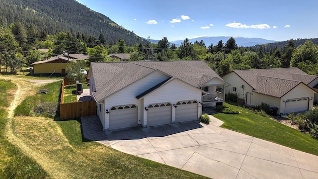 1585 Stanley St, Missoula, MT 59802 - view of front of home featuring concrete driveway, an attached garage, a front lawn, and a mountain view