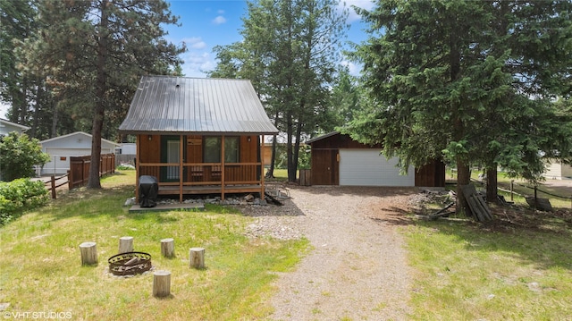34045 Redgate Dr, Bigfork, MT 59911 - chalet / cabin featuring an outbuilding, a detached garage, driveway, a metal roof, and a porch