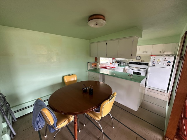 521 N Central Ave, Ekalaka, MT 59324 - kitchen with white appliances, a peninsula, white cabinetry, and light wood finished floors