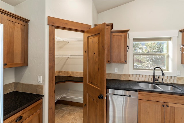 150 Swede Trl, Kalispell, MT 59901 - kitchen featuring dishwasher, lofted ceiling, brown cabinetry, and dark stone counters