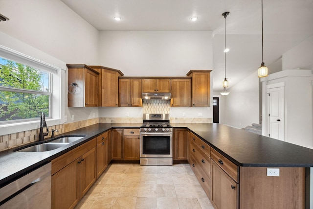 150 Swede Trl, Kalispell, MT 59901 - kitchen with appliances with stainless steel finishes, brown cabinets, under cabinet range hood, dark countertops, and high vaulted ceiling