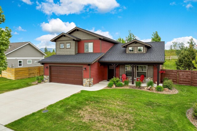 150 Swede Trl, Kalispell, MT 59901 - view of front of home featuring covered porch, an attached garage, stone siding, concrete driveway, and a shingled roof