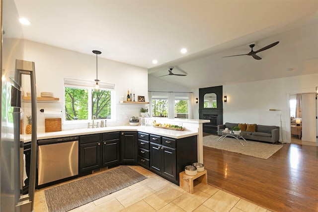 15660 Sara Jo Ln, Frenchtown, MT 59834 - kitchen with stainless steel dishwasher, ceiling fan, open shelves, a fireplace, and vaulted ceiling