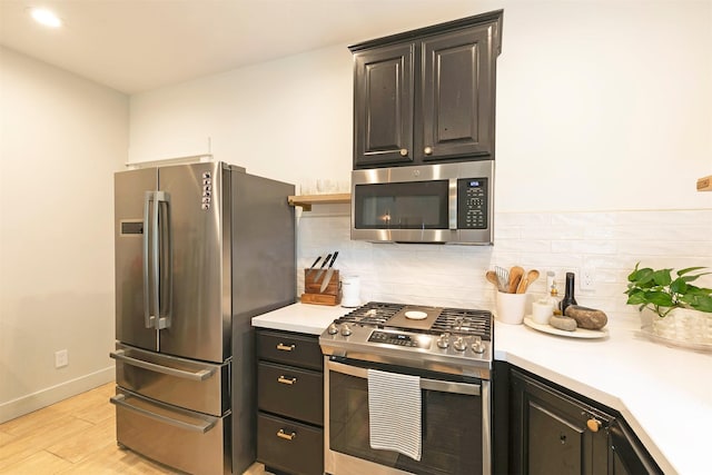 15660 Sara Jo Ln, Frenchtown, MT 59834 - kitchen with appliances with stainless steel finishes, decorative backsplash, light countertops, and light wood-style floors