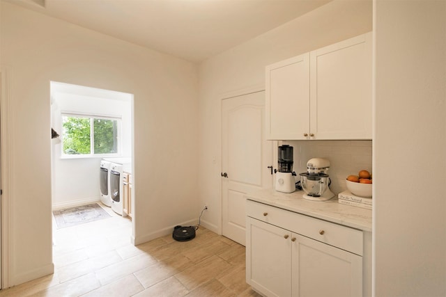 15660 Sara Jo Ln, Frenchtown, MT 59834 - kitchen with washing machine and dryer, decorative backsplash, white cabinetry, and light stone countertops