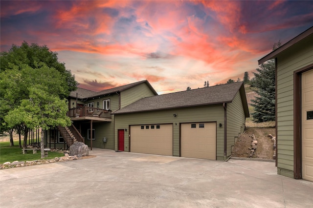 15660 Sara Jo Ln, Frenchtown, MT 59834 - view of front facade with stairway, a deck, driveway, a garage, and a shingled roof