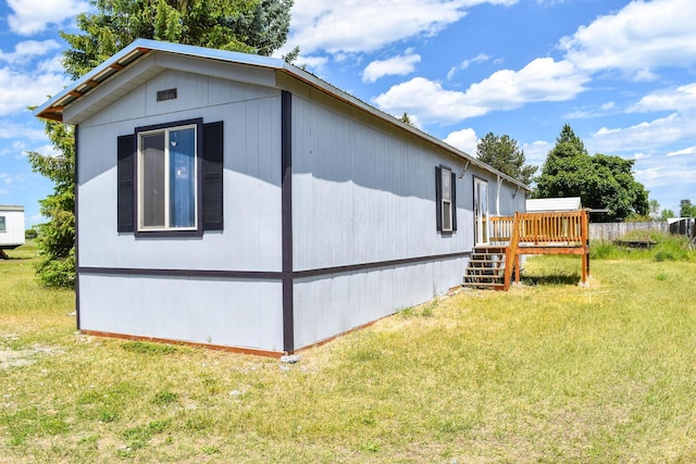 36240 Felsman St, Pablo, MT 59855 - view of home's exterior featuring a deck, a lawn, and stairs
