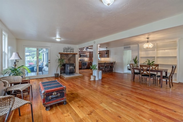 3422 Rimini Rd, Helena, MT 59601 - living area featuring a wood stove, light wood-type flooring, and a chandelier