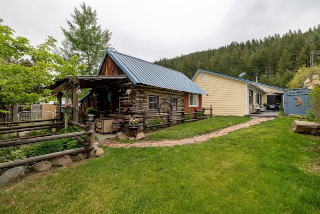 3422 Rimini Rd, Helena, MT 59601 - back of property with a metal roof, a forest view, and log exterior
