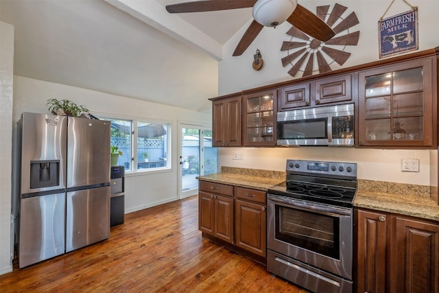 3422 Rimini Rd, Helena, MT 59601 - kitchen featuring stainless steel appliances, wood finished floors, light stone countertops, ceiling fan, and glass insert cabinets