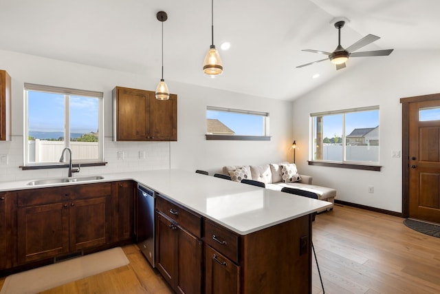 915 Stewart Loop, Bozeman, MT 59718 - kitchen with a peninsula, stainless steel dishwasher, tasteful backsplash, light countertops, and lofted ceiling