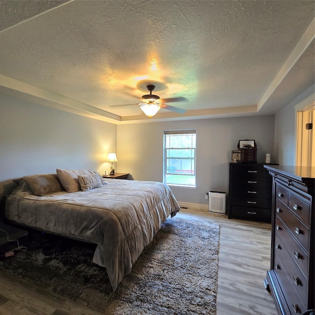 104 39th Ave NE, Great Falls, MT 59404 - bedroom with a tray ceiling, a textured ceiling, light wood finished floors, and a ceiling fan
