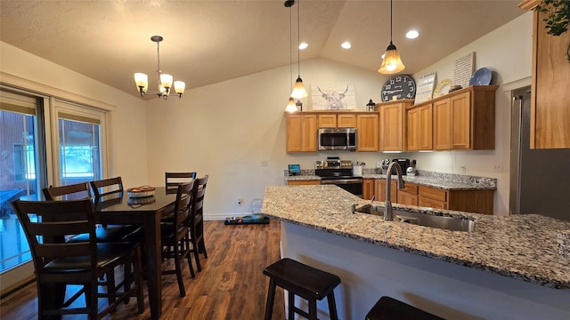 104 39th Ave NE, Great Falls, MT 59404 - kitchen featuring appliances with stainless steel finishes, lofted ceiling, a kitchen bar, dark wood-type flooring, and brown cabinetry