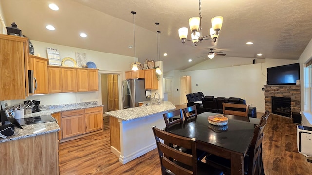104 39th Ave NE, Great Falls, MT 59404 - kitchen with stainless steel appliances, ceiling fan, vaulted ceiling, light wood-style flooring, and a fireplace