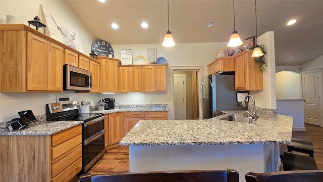 104 39th Ave NE, Great Falls, MT 59404 - kitchen featuring appliances with stainless steel finishes, a peninsula, light wood-type flooring, a breakfast bar area, and light stone countertops