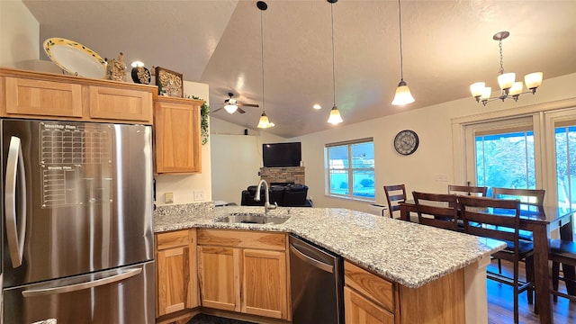 104 39th Ave NE, Great Falls, MT 59404 - kitchen with stainless steel appliances, a peninsula, vaulted ceiling, a ceiling fan, and light stone counters