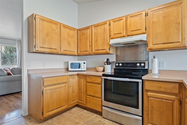 251 Grandview Way, Missoula, MT 59803 - kitchen with stainless steel range with electric cooktop, white microwave, under cabinet range hood, and light countertops