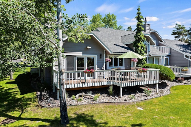7 Eagle Bend Dr, Bigfork, MT 59911 - rear view of house featuring a deck, a lawn, and roof with shingles