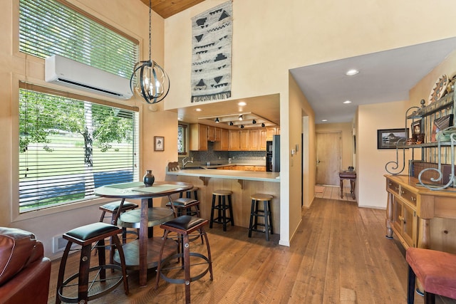 7 Eagle Bend Dr, Bigfork, MT 59911 - dining area featuring a wall unit AC, light wood-type flooring, a high ceiling, a chandelier, and recessed lighting