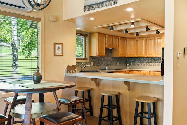 7 Eagle Bend Dr, Bigfork, MT 59911 - kitchen with backsplash, a breakfast bar, a wall mounted AC, light countertops, and light brown cabinets