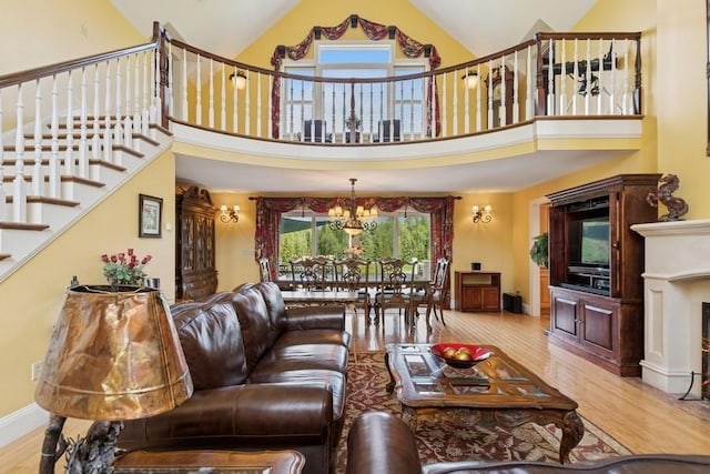 420 Little Creek Ln, Whitefish, MT 59937 - living area featuring stairs, wood finished floors, high vaulted ceiling, a chandelier, and a fireplace