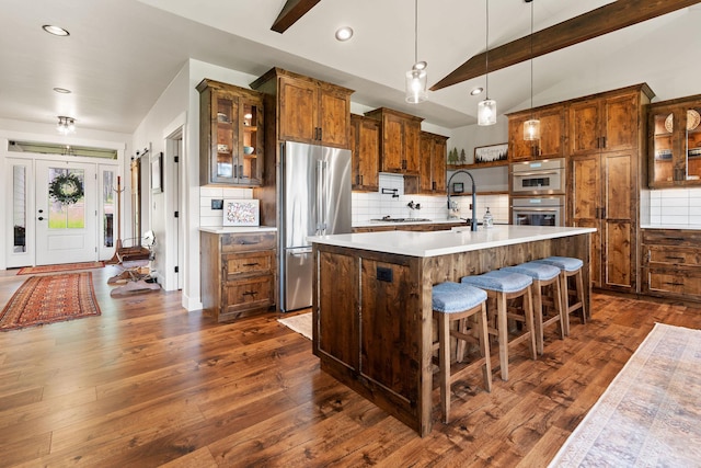 331 Deer Creek Rd, Somers, MT 59932 - kitchen featuring stainless steel appliances, lofted ceiling, decorative backsplash, light countertops, and dark wood-style floors