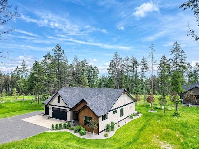 331 Deer Creek Rd, Somers, MT 59932 - view of front of property featuring driveway, a shingled roof, a garage, and a front yard