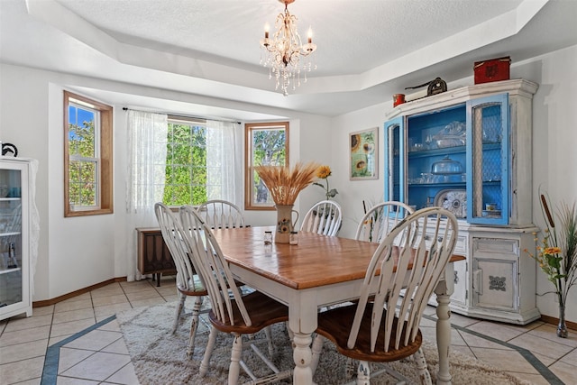 4786 Hereford Ln, Stevensville, MT 59870 - dining room featuring light tile patterned flooring, a tray ceiling, a chandelier, inlaid floor details, and a textured ceiling