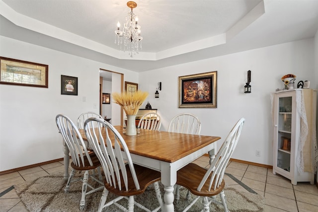 4786 Hereford Ln, Stevensville, MT 59870 - dining area featuring light tile patterned floors, a chandelier, and a tray ceiling