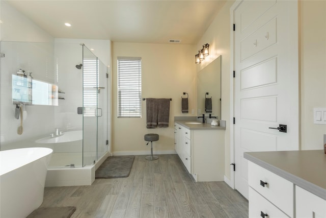343 Meadow View Loop, East Helena, MT 59635 - full bath with vanity, wood finished floors, a soaking tub, a shower stall, and recessed lighting