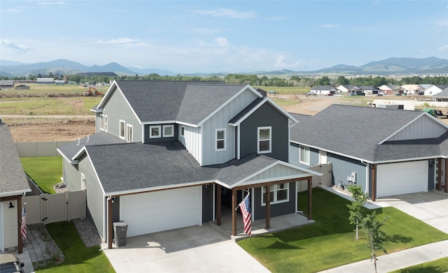 343 Meadow View Loop, East Helena, MT 59635 - view of front of property featuring board and batten siding, driveway, a mountain view, a porch, and a gate