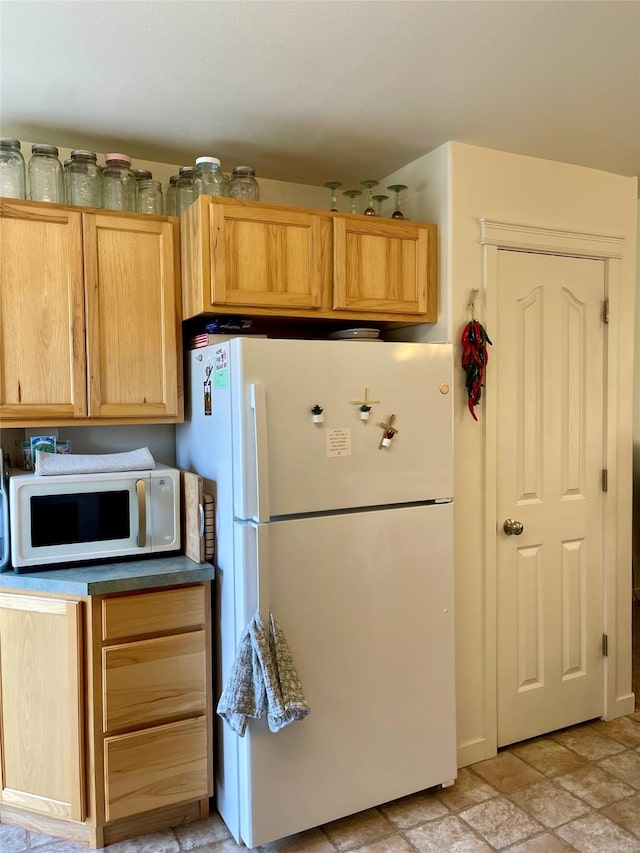50 Rockefeller Dr, Kalispell, MT 59901 - kitchen with white appliances and stone finish flooring