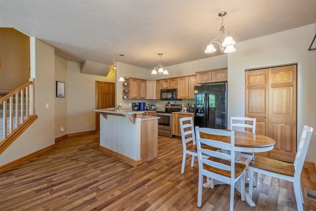 310 Barney St Unit B, Helena, MT 59602 - kitchen featuring black appliances, a chandelier, open shelves, wood finished floors, and a breakfast bar area