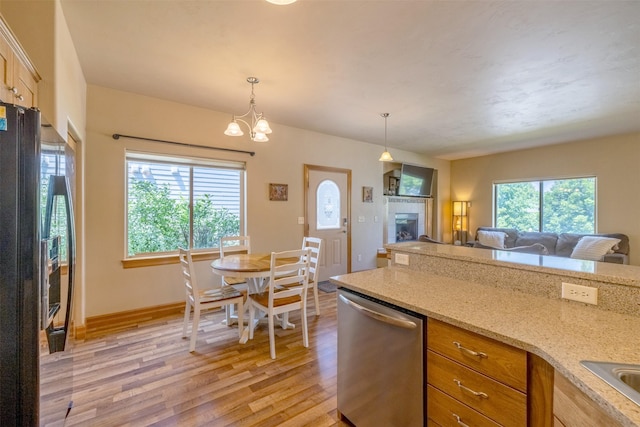 310 Barney St Unit B, Helena, MT 59602 - kitchen with dishwasher, light wood finished floors, freestanding refrigerator, open floor plan, and hanging light fixtures