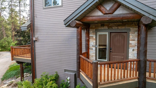 396 N Juniper Bay Rd Unit 15, Somers, MT 59932 - view of exterior entry featuring stone siding and a wooden deck