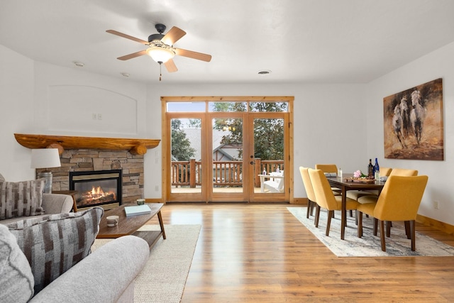 396 N Juniper Bay Rd Unit 15, Somers, MT 59932 - living room with light wood-type flooring, a stone fireplace, and ceiling fan