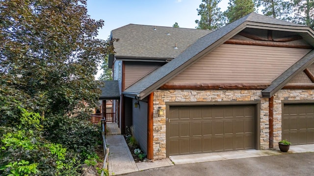 396 N Juniper Bay Rd Unit 15, Somers, MT 59932 - view of front facade with stone siding, a shingled roof, and driveway
