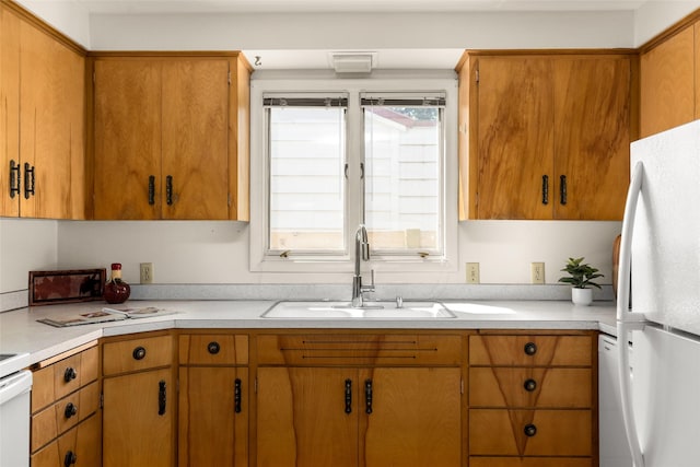 1120 8th Ave E, Kalispell, MT 59901 - kitchen featuring freestanding refrigerator, light countertops, and brown cabinets