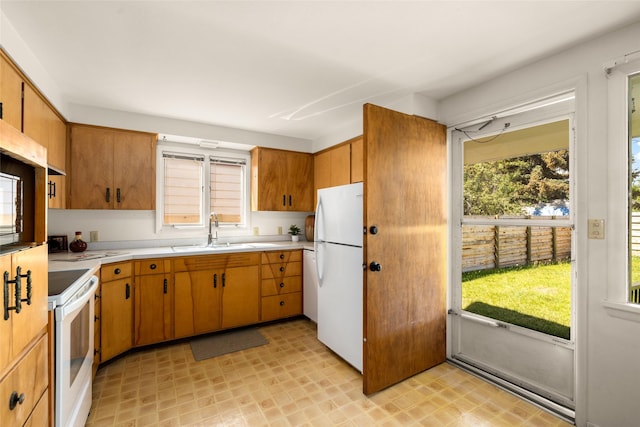 1120 8th Ave E, Kalispell, MT 59901 - kitchen with white appliances, light countertops, light flooring, and brown cabinetry