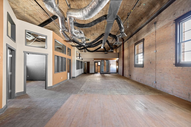 300 2nd St E Unit 2, Whitefish, MT 59937 - spare room featuring a towering ceiling, wood-type flooring, and brick wall