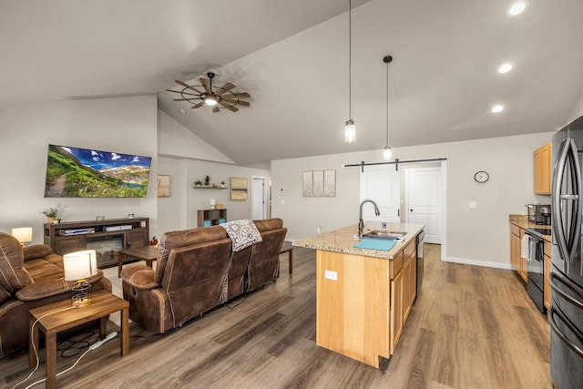 546 Sparrow Rd, Kalispell, MT 59901 - kitchen featuring open floor plan, a barn door, ceiling fan, vaulted ceiling, and wood finished floors