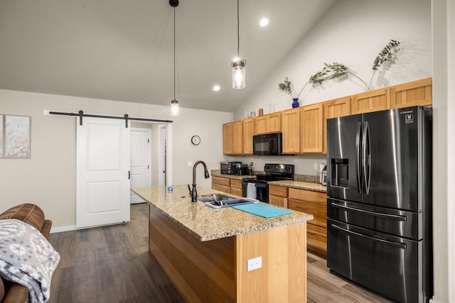 546 Sparrow Rd, Kalispell, MT 59901 - kitchen with black appliances, dark wood finished floors, a center island with sink, vaulted ceiling, and a barn door