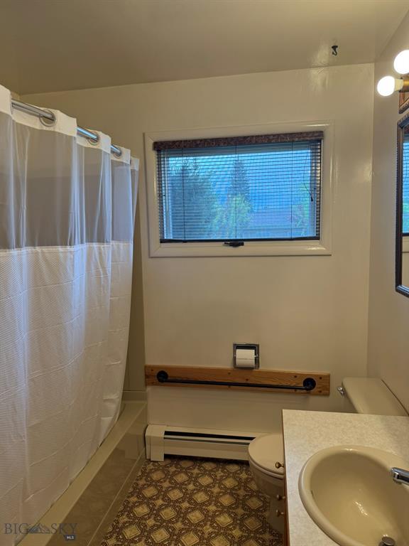2625 George St, Butte, MT 59701 - bathroom featuring a baseboard radiator, vanity, shower / tub combo, and tile patterned flooring