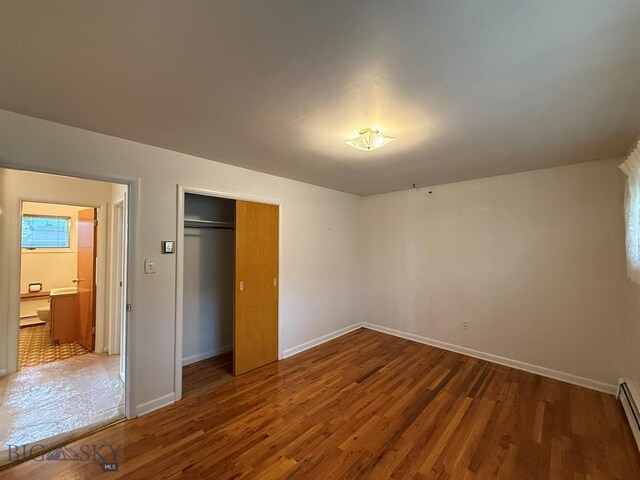 2625 George St, Butte, MT 59701 - unfurnished bedroom featuring wood finished floors, baseboard heating, and a closet