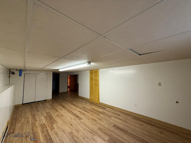 2625 George St, Butte, MT 59701 - finished below grade area with light wood finished floors, a paneled ceiling, and a baseboard radiator