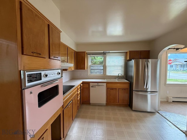 2625 George St, Butte, MT 59701 - kitchen with white appliances, under cabinet range hood, healthy amount of natural light, and brown cabinetry