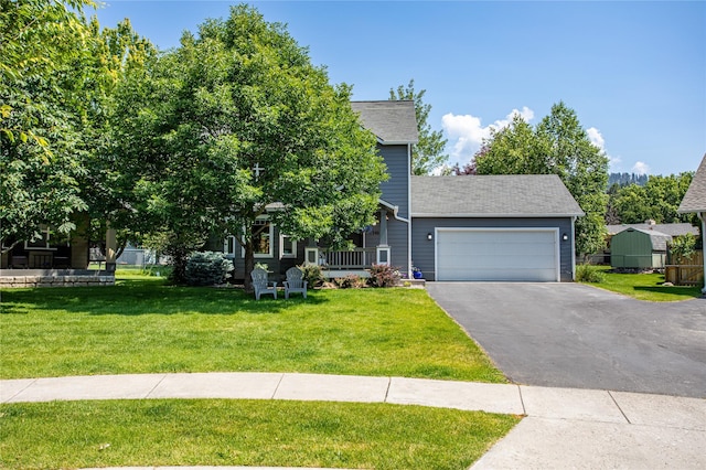 1346 Lilly Ct, Missoula, MT 59802 - view of property hidden behind natural elements featuring a front yard, a garage, and asphalt driveway